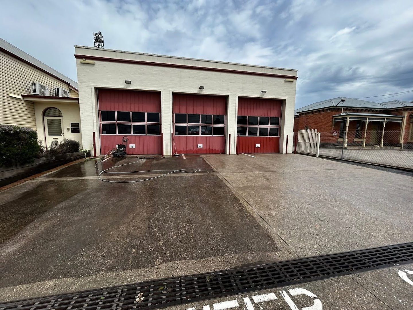 A wet concrete forecourt in front of a Ballarat fire station