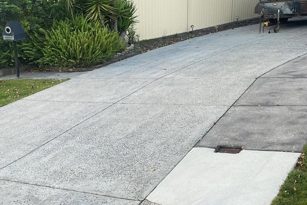 A clean concrete driveway running out to the street