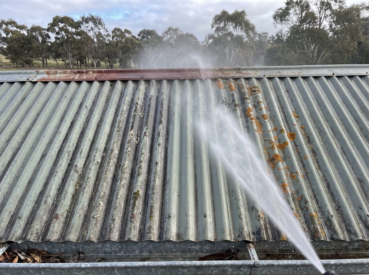 A corrugated metal roof being washed down with water