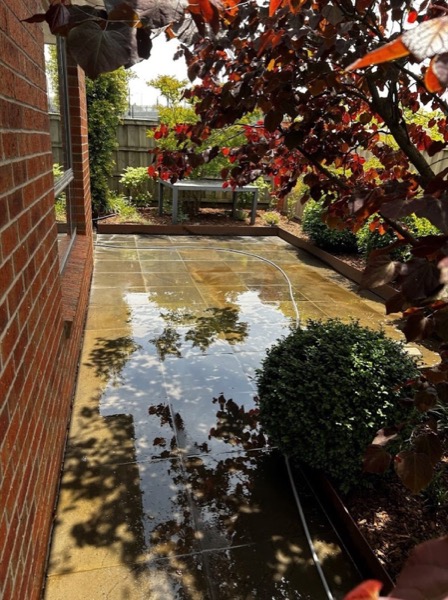 A bluestone courtyard with a garden fountain, photographed before pressure washing