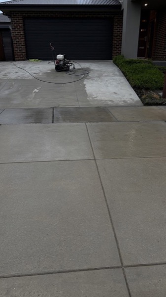 A surface cleaner attachment sitting on a concrete driveway