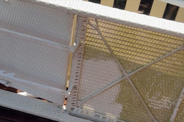 A white shade structure being washed from below