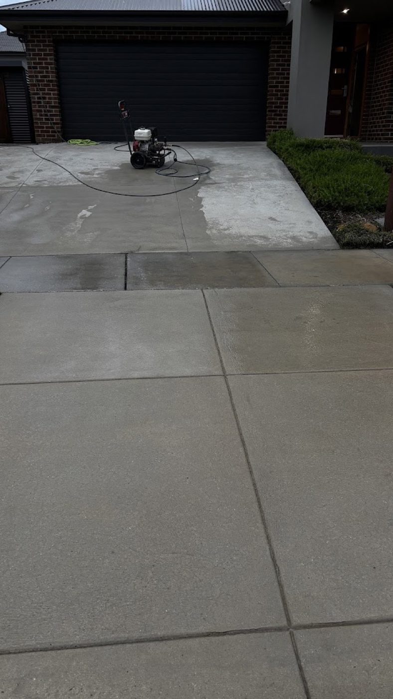 A surface cleaner attachment sitting on a concrete driveway